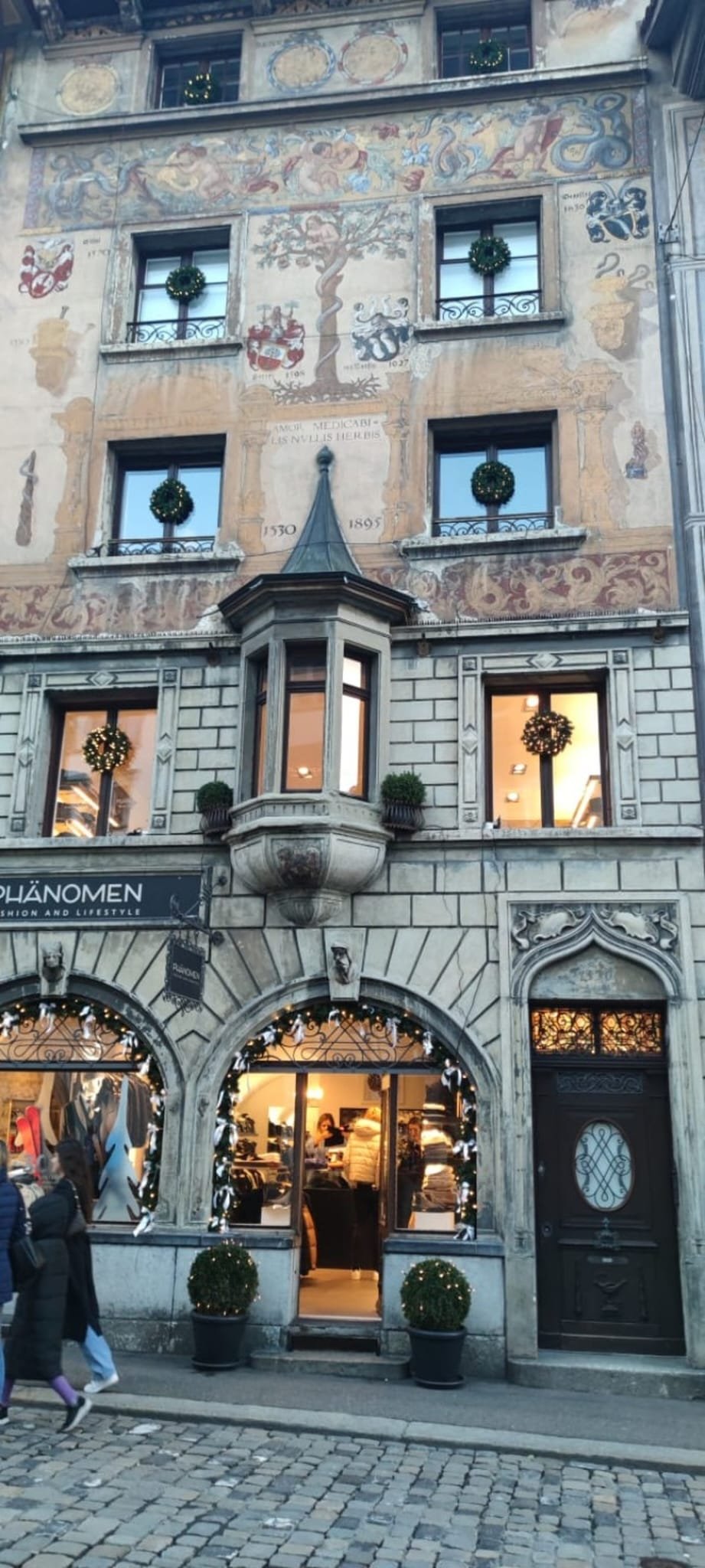 Painted historic fresco facade in Lucerne Old Town with festive window decorations