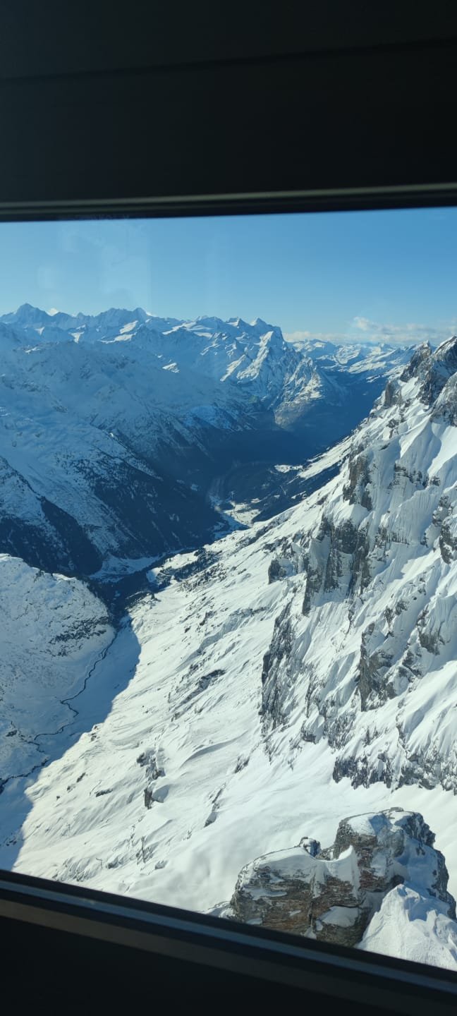 Steep snow-covered Pilatus slopes and alpine valley seen from a cable car viewpoint