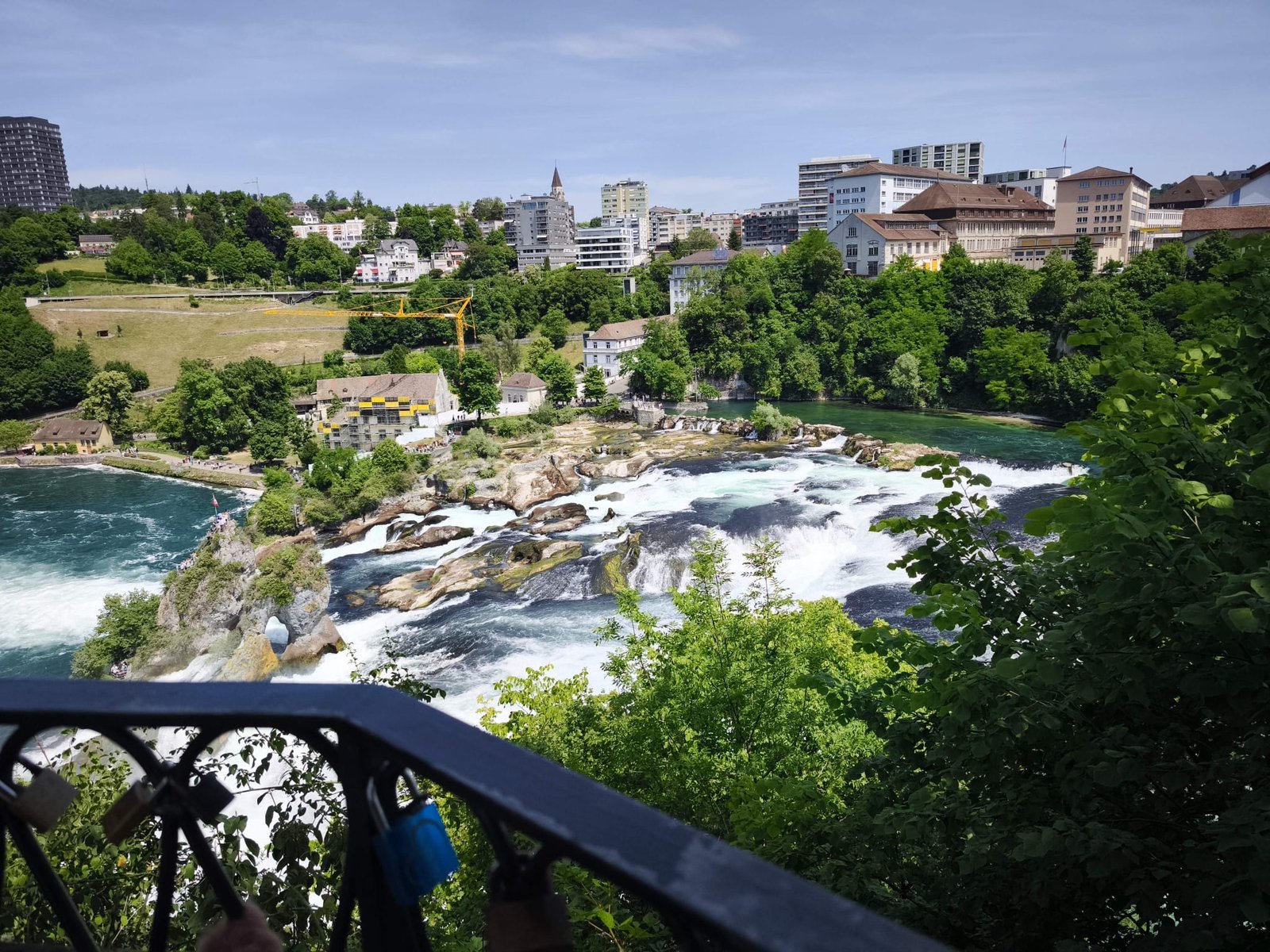 Powerful Rhine Falls cascade flowing around the famous rock island with Swiss flag at Schaffhausen