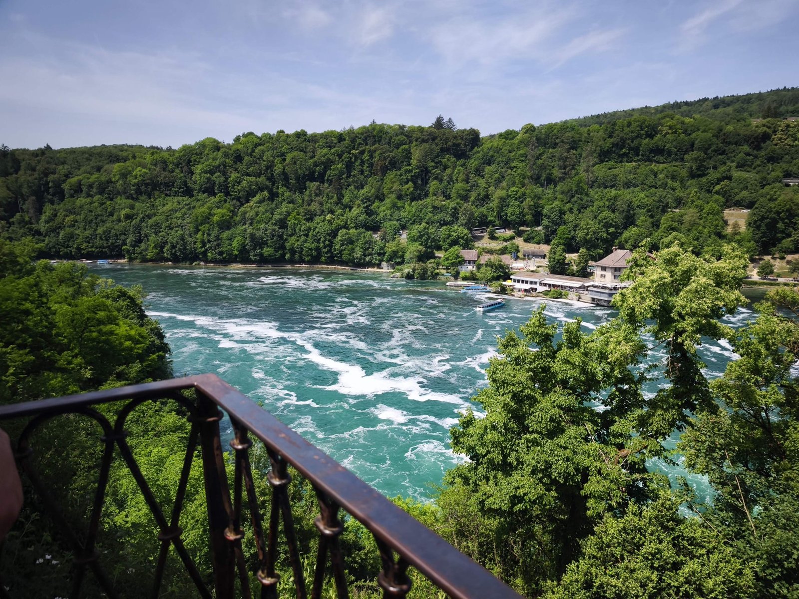 Churning white-water rapids at Rhine Falls seen from an elevated viewing balcony
